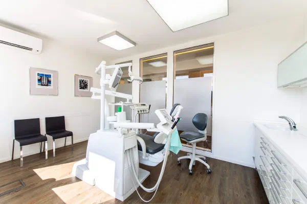 Behandlungszimmer mit Zahnarztstuhl und Milchglas-Trennwand